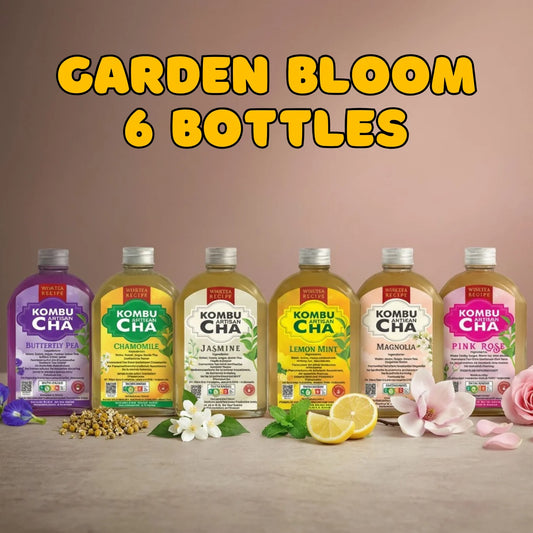 Six bottles of KombuCha with floral flavors on a wooden surface, featuring flowers and herbs.
